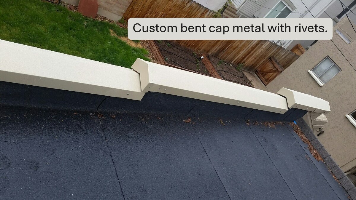 Custom white metal coping cap installed on a parapet wall.